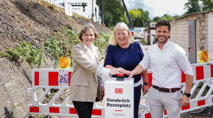 B�rbel Aissen, Leiterin Bahnh�fe Nord DB InfraGO, Carmen Schwabl, Sprecherin der Gesch�ftsf�hrung der Landesnahverkehrsgesellschaft Niedersachen (LNVG) und Ren� Bei der Sandwisch, Fachdienstleiter Verkehrsanlagen der Stadt Osnabr�ck, dr�ckten gemeinsam auf den roten Knopf zur Freigabe der Bauarbeiten.